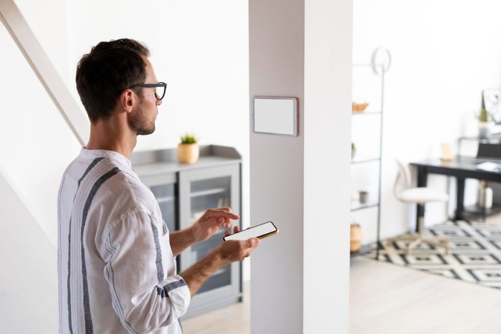 A man adjusting a smart thermostat in his home. 