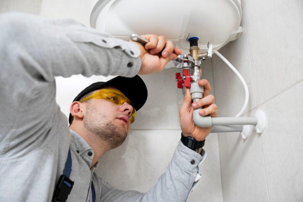 A handyman changing parts of a water heater.