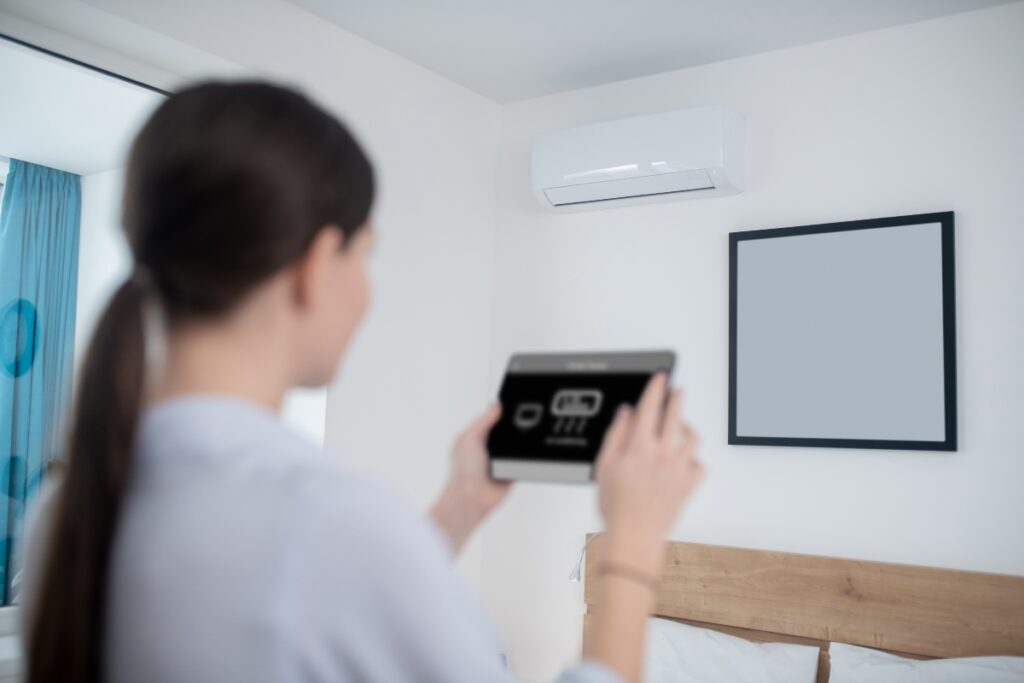A homeowner controlling the AC with a tablet.