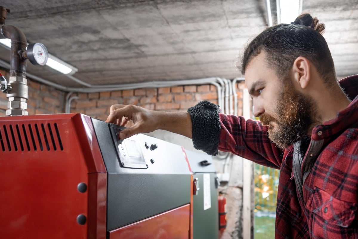 A man getting a furnace serviced before summer.